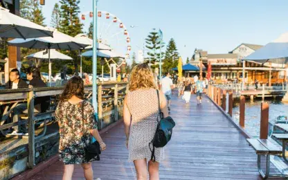 two women walking along a pier